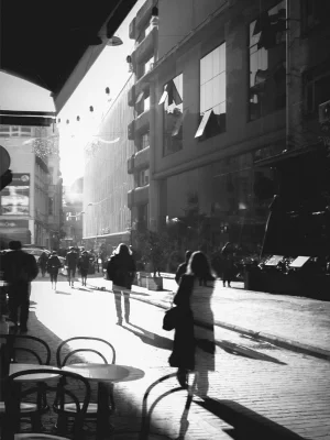 paseantes caminando por una calle en blanco y negro
