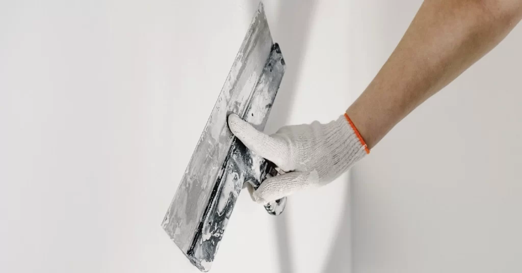 pintor aplicando pintura blanca en una pared