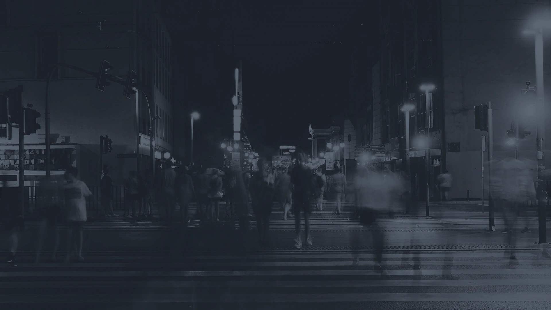 gente cruzando un paso de peatones por la noche
